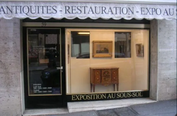 La devanture d'Antiquités Pugin : un auvent clair, une vitrine
         noire et une porte vitrée au numéro 59.